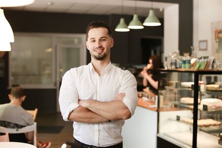 Young male caucasian businessman standing with at cafe. Concept of business and success.の写真素材