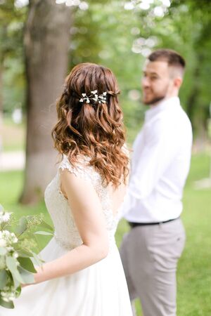 Caucasian happy fiancee walking with groom and bouquet of flowers. Concept of bridal photo session and married couple.の写真素材