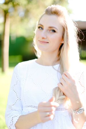 Portrait of young beautiful blonde woman wearing white clothes. Concept of beauty and female person.の写真素材