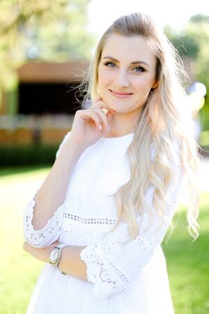 Portrait of young smiling blonde woman wearing white clothes. Concept of beauty and female person.の写真素材