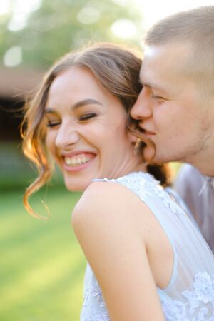 Close up portrait of groom kissing bride outside. Concept of love and happy couple.の写真素材