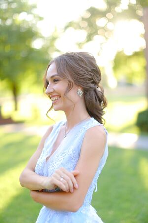 aucasian smiling fiancee walking in park. oncept of bridal hair do and wedding photo session on nature.の写真素材