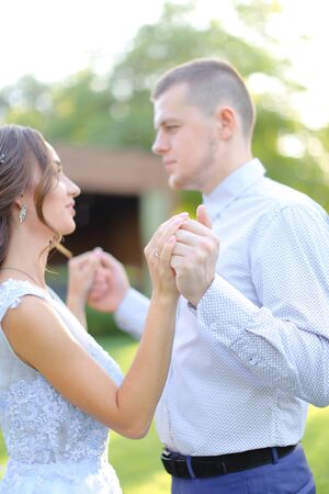 Young caucasian pretty fiancee dancing with groom in park. Concept of wedding and love.の写真素材