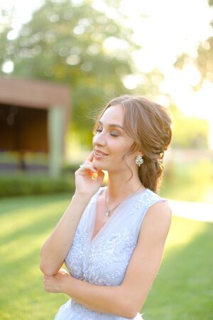 American pretty fiancee standing in park. oncapt of bridal hair do and wedding photo session on nature.の写真素材