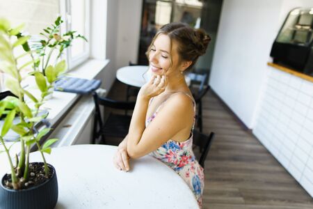 Young married american woman resting at cafe and resting, waiting husband. Concept of photo session at restaurant.の写真素材