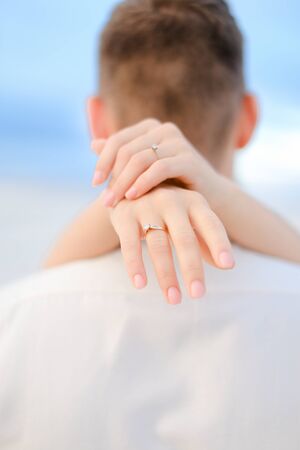 Back view of female arms holding man neck. Concep of love.の写真素材