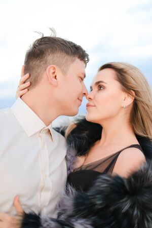 Portrait of man hugging woman wearing fur coat in white background. Concept of love nad relationship.の写真素材