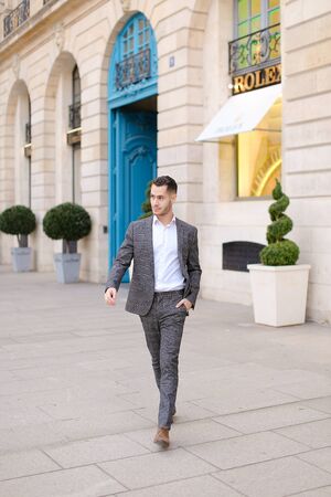 Young european man walking in city and wearing grey suit. Concept of fashion and businessman.の写真素材