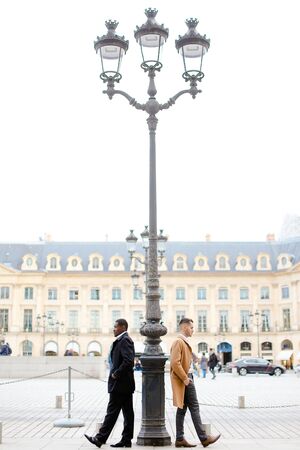 Afro american and caucasian boys standing near street lantern, wearing suits. Concept of urban photo session and life style.の写真素材