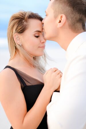 Young man kissing girl in white background. Concept of love.の写真素材