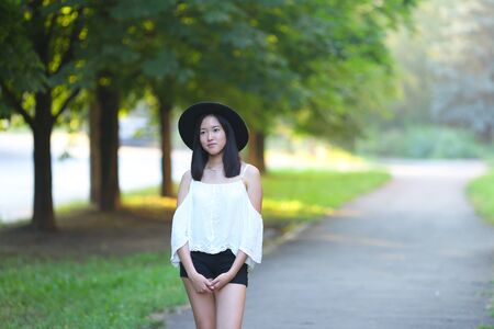 female hat nature summer sun sunset looks pleased. azitka woman black hair dancing around trees.の写真素材