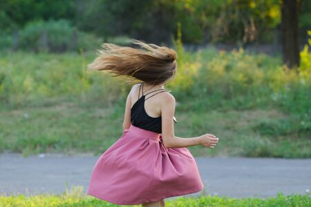 Woman with long hair and beautiful eyes on a green background shows the different human emotions. Lady portrays dancing, jumping, fun, happiness, smileの写真素材