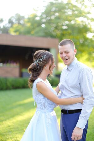 Young happy caucasian fiancee dancing with groom in park. Concept of wedding and love.の写真素材