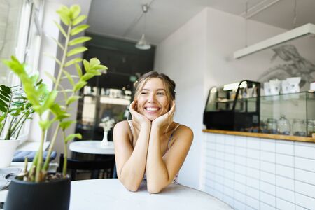 Young lovely girl sitting at cafe and waiting boyfriend. Concept of taking rest and beautiful female person.の写真素材