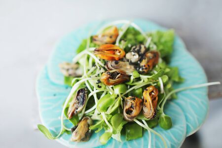 Tasty thai salad with mussels on white plate. Concept of seafood and exotic menu in Thailand.の写真素材