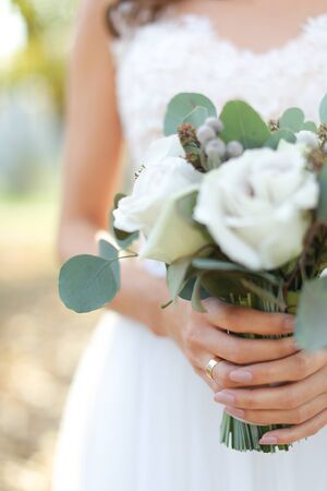 Closeup bride bouquet of white roses. Concept of photo session and flowers composition.の写真素材