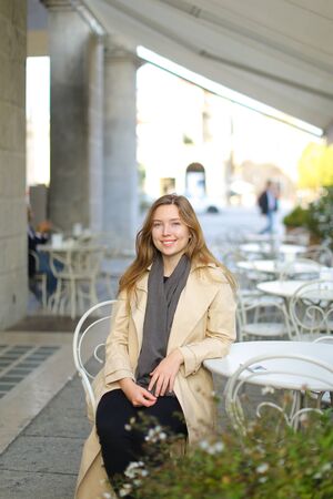 Young caucasian woman sitting at street cafe in Paris, France. Concept of trip to Europe.の写真素材