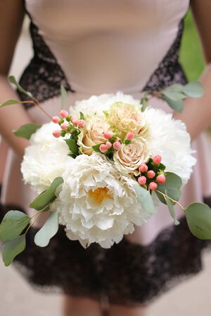 Closeup amazing bouquet of roses in bride hands. Concept of bridal flower composition and froristic art.の写真素材
