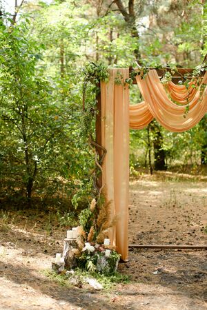 Yellow decorated wedding arch in park. Concept of bridal and marriage ceremony place and outdoor nuptials.の写真素材