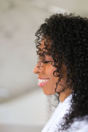 Portrait of smiling afro american curly haired young woman. Concept of african female beauty.の写真素材
