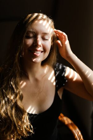 Close up portrait of young smiling girl with striped shadows. Concept of private photo session and...