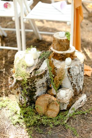 White candles on handmade stumps near wedding altar or arch. Concept of wedding decorations.の写真素材