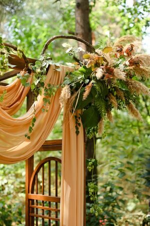 Yellow wonderful decorated wedding arch in park. Concept of bridal and marriage ceremony place and outdoor nuptials.の写真素材