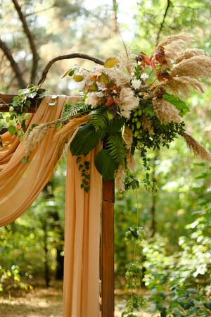 Yellow wonderful decorations on wedding arch in park. Concept of bridal and marriage ceremony place and outdoor nuptials.の写真素材