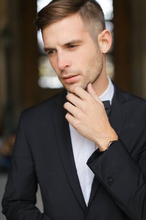 Portrait of young man wearing black suit with bow tie and white shirt. Concept of male groom model.の写真素材