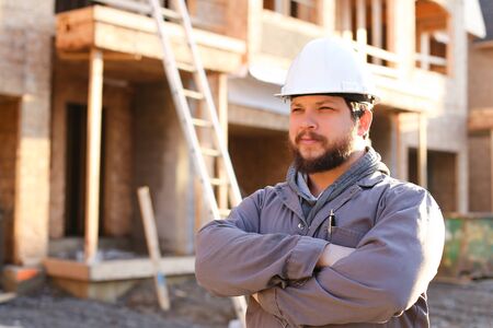 Portrait of foreman or builder wearing hardhat on construction site. Concept of professions and working abroad.の写真素材