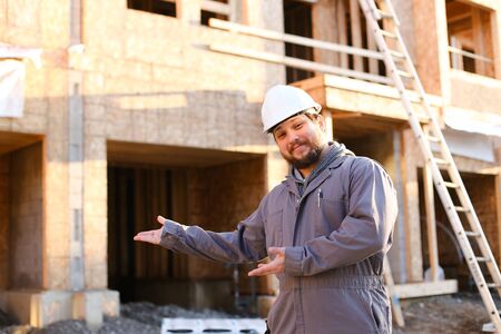 Portrait of architect and foreman showing ready building and wearing hardhat.の写真素材