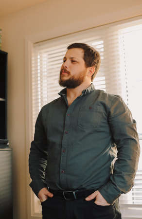 Portrait of smart caucasian man standing at office and wearing grey shirt. Concept of business fahion style.の写真素材