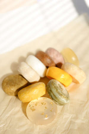 Many bars of colorful scented handmade eco soap with essential eco soaps for skincare and body. Concept of advertisment of natural online shop for skin and non gmo organic cosmetics in europe.の写真素材