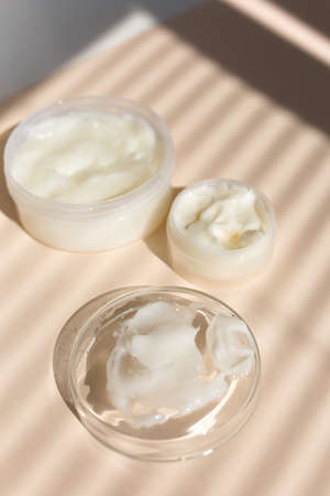 Natural eco homemade facial balm in white jar, striped shadow background. Concept of natural organic non gmo cosmetic and koshe products.の写真素材