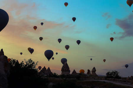 Hot air ballons flying over Cappadocia in sunset sky. Concept of trip to Turkey, turkish festival.の写真素材