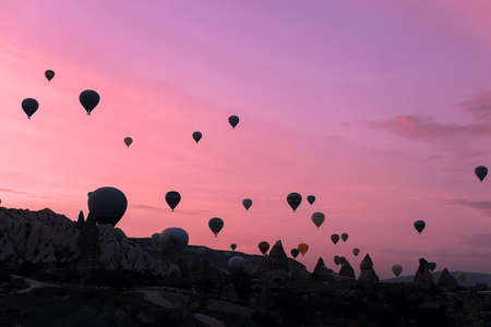 Colorful hot air balloons flying over Cappadocia rocks. Concept of vacations in Turkey and turkish festival.の写真素材