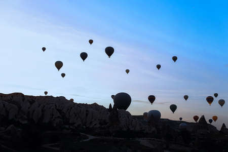 Many hot air balloons flying over Cappadocia rocks. Concept of vacations in Turkey and turkish festival.の写真素材