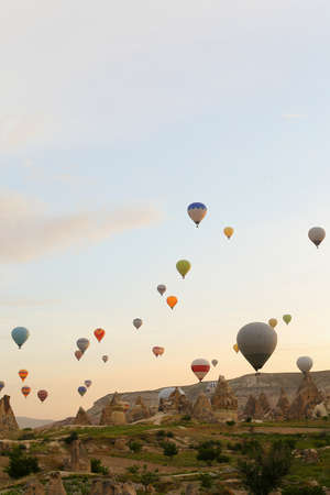 Many big hot air balloons flying over Cappadocia rocks. Concept of vacations in Turkey and turkish festival.の写真素材