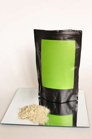 Close up black doy pack with cosmetic product and green space for your brand, powder on glass.. Concept of cluelty free, organic, kosher flour and organic cosmetics online shop.の写真素材