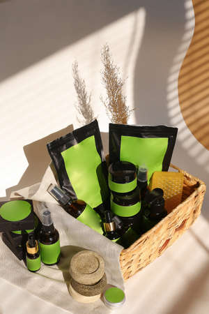 Cosmetic bottles, jars and doy packs in wicker basket with green space for brand. Concept of organic cosmetics and cluelty free kosher products in online shop.の写真素材