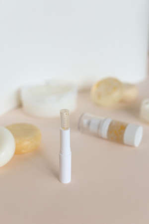 Roller bottles with essential oil perfums and hygiene lipsticks in striped shadow background. Concept of handmade cosmetic and natural organic products for healthcare.の写真素材