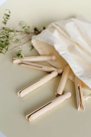 Wooden Ñlothespins in white tissue bag on light background. Concept of ecological organic...
