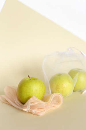 Green apples in reusable eco friendly transparent bags on bright background with copy space. Concept of zero waste shopping, reducing plastic, stop pollution.の写真素材