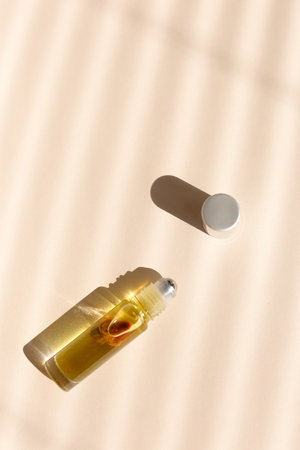 Top view of roller bottle on striped shadow beige background.の写真素材