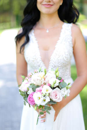 Close up bouquet of flowers in brunette bride hands.の写真素材
