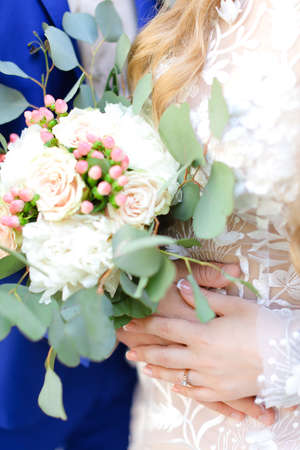 Close up bouquet of flowers in bride and groom hands.の写真素材