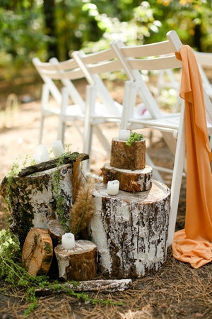 White candles near chairs in garden on wedding ceremony place.の写真素材
