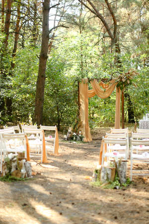 Yellow beautiful wedding altar and white chairs in garden.の写真素材