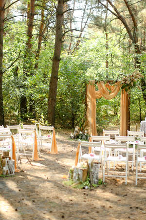Yellow wonderful wedding altar and white chairs in garden.の写真素材