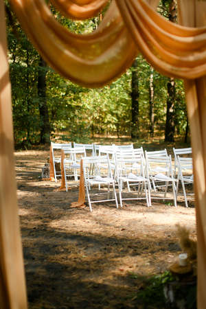 White wedding chairs near altar in forest.の写真素材